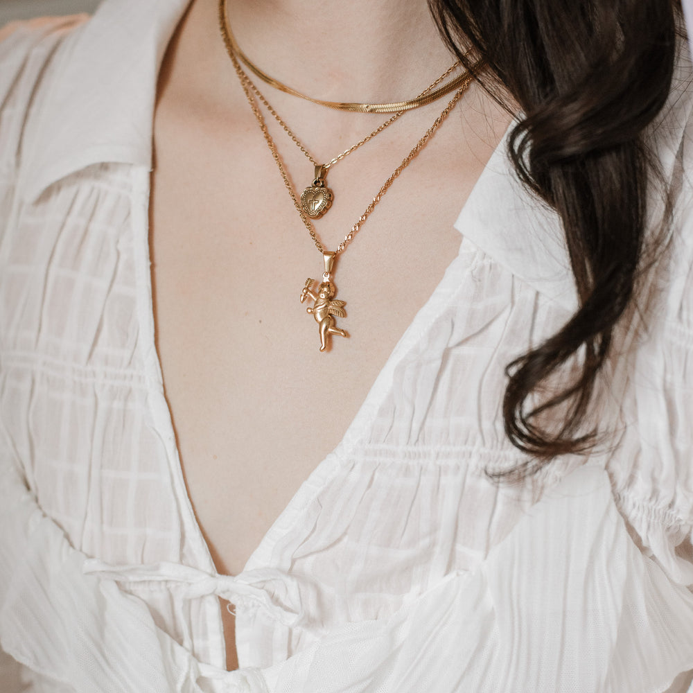 Coquette girl wearing a white dress with layered gold romantic necklaces