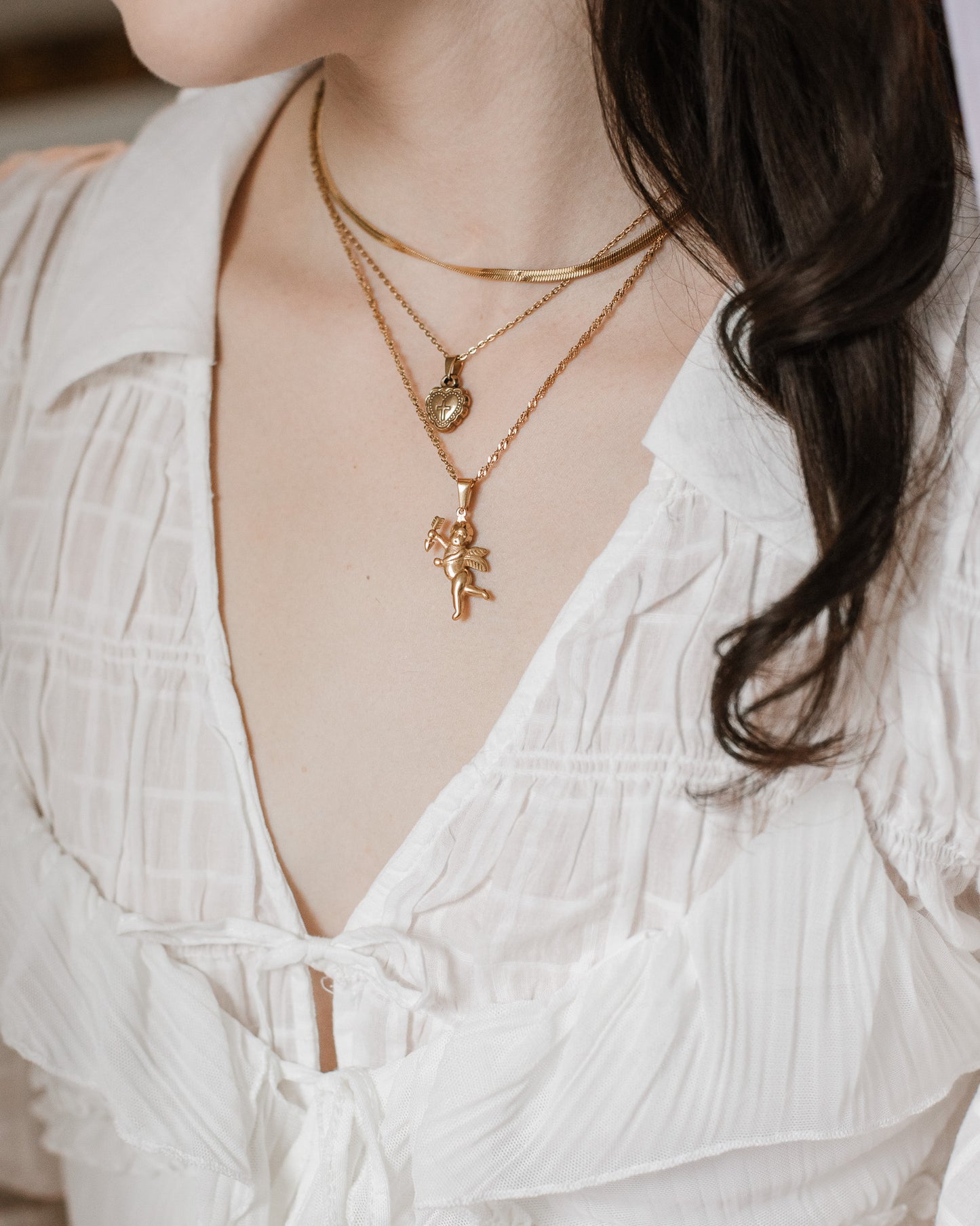 Coquette girl wearing a white dress with layered gold romantic necklaces