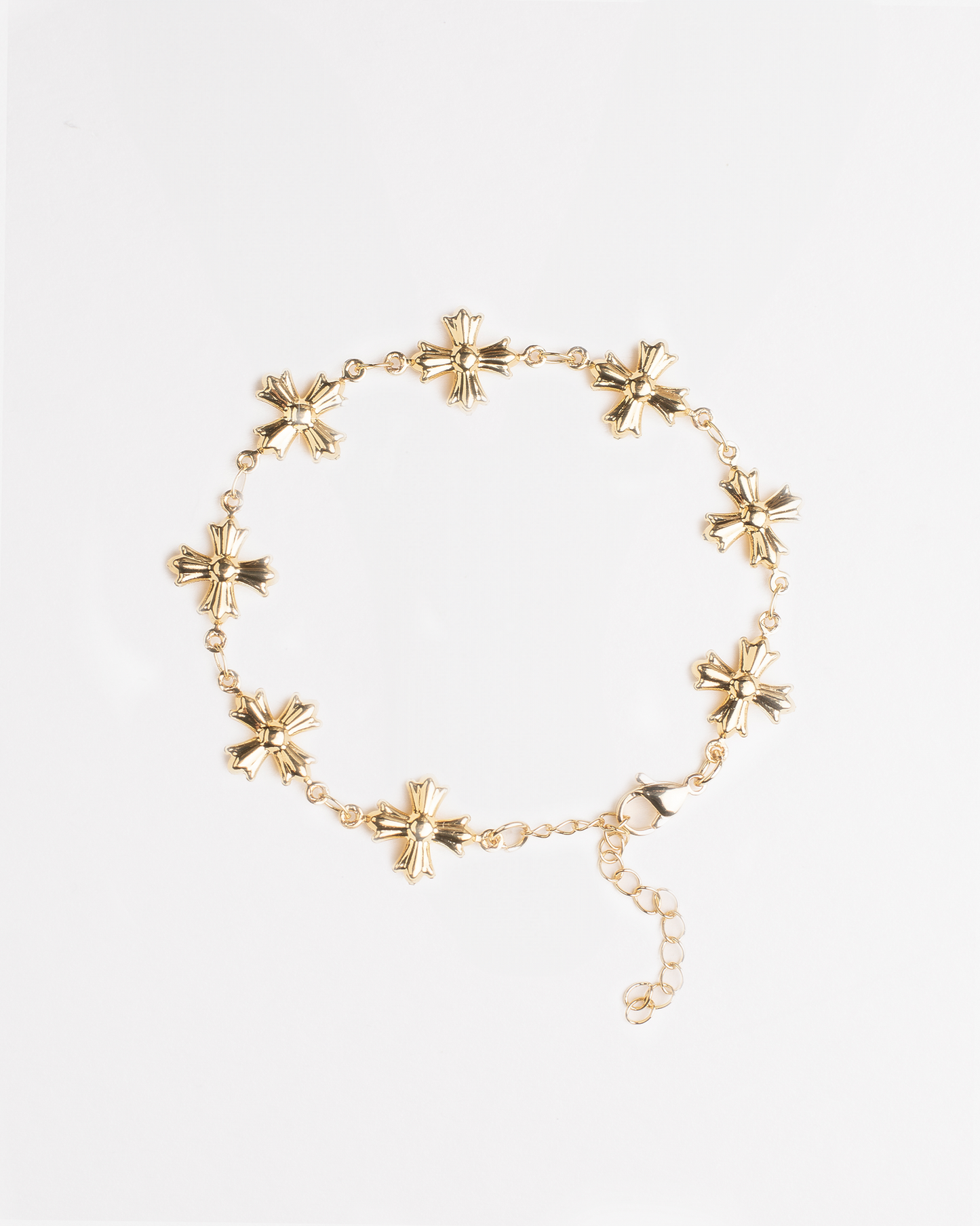 Gold bracelet with vintage cross design on a white background