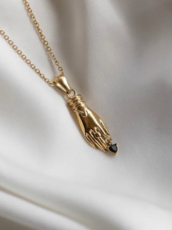 Gold necklace with unique vintage inspired hand pendant with a black heart shaped gemstone, materials used a waterproof and tarnish resistant