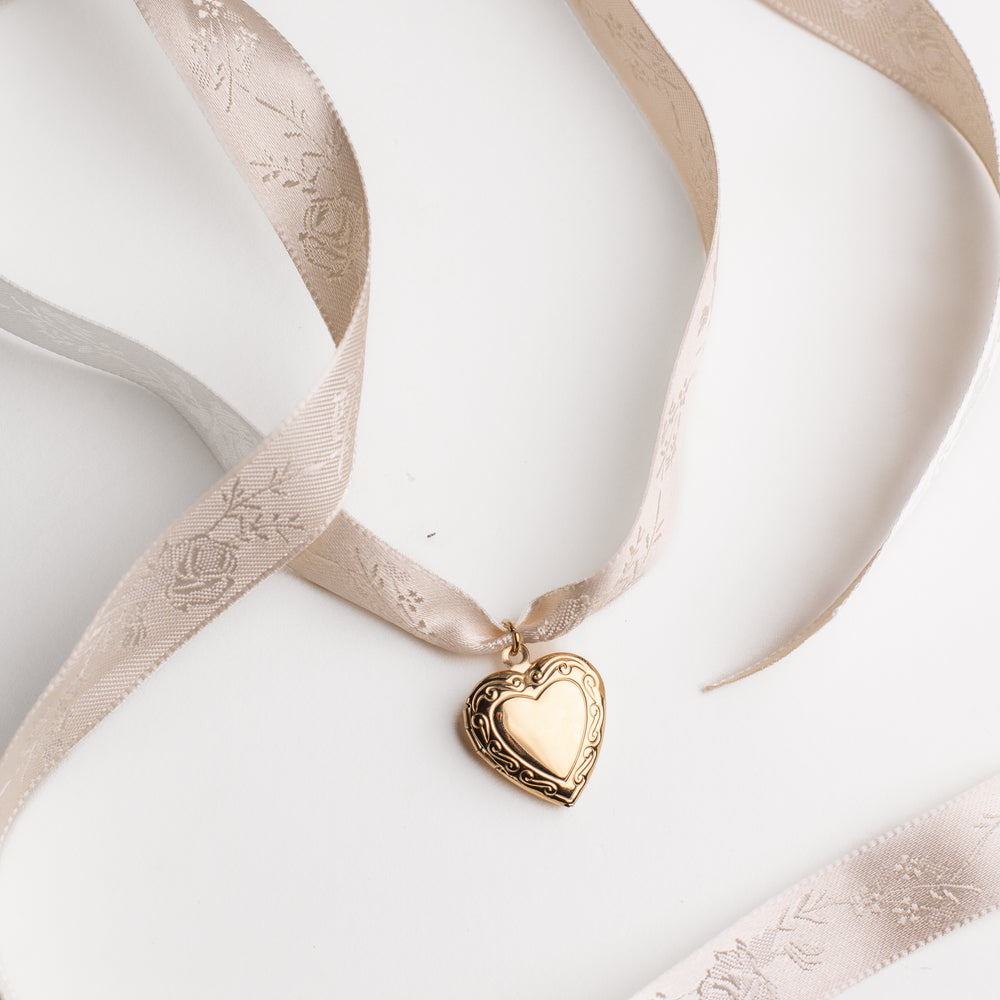 
                  
                    Minimalistic vintage gold heart locket pendant on a white background
                  
                