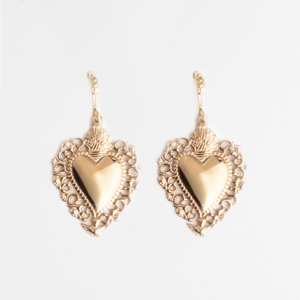 Gold vintage heart shaped earrings on a white background