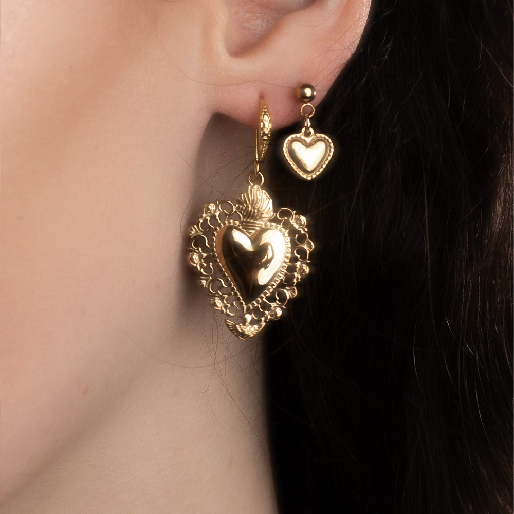Gold vintage heart shaped earrings worn together with minimalistic heart stud earrings