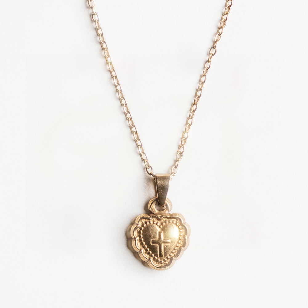 Gold heart shaped pendant necklace with a cross design on a white background